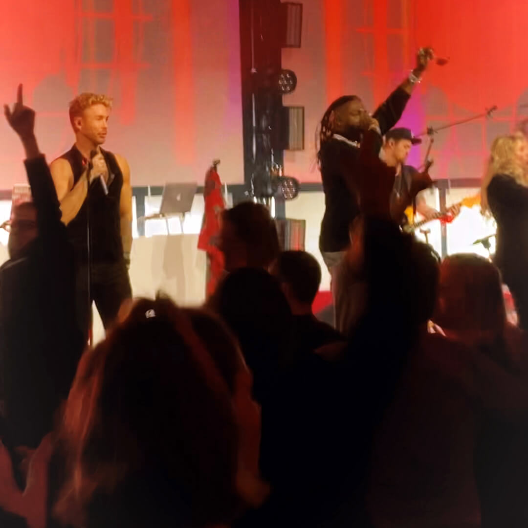 Bild vom abendlichen Get together, zu sehen ein musikalische Bühnenperformance aus dem Publikum heraus fotografiert